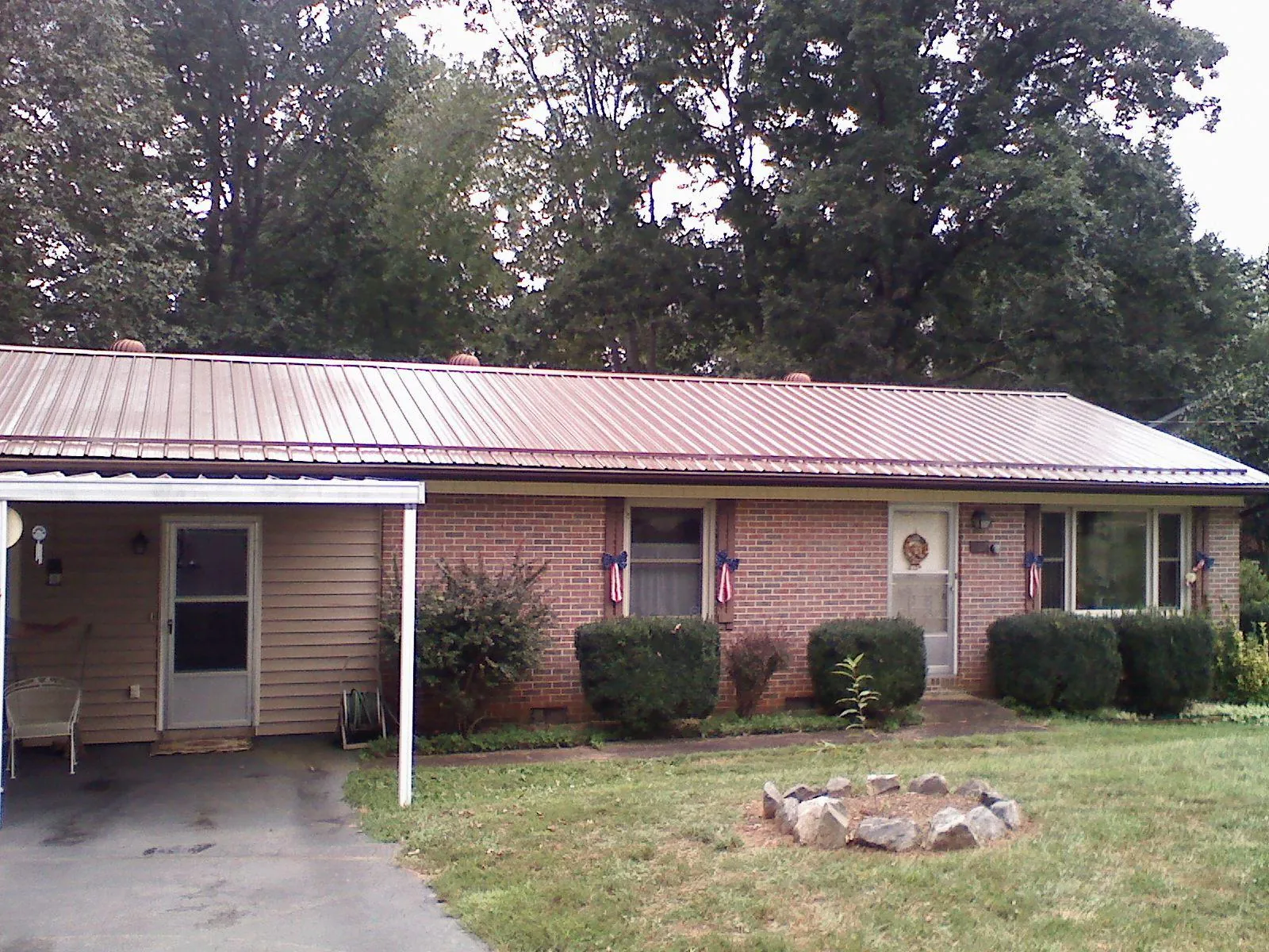 Bronze metal roof and carport on a brick ranch home — Roof Repair work by our crew in Daleville